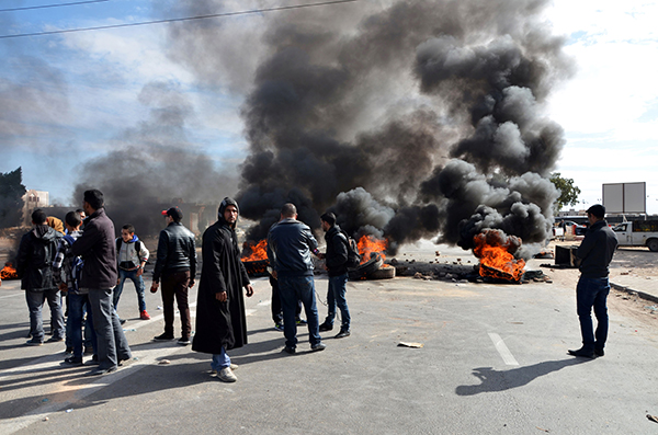 Young Tunisian graduates block the road with burning tyres in the southeastern town of Medenine, on Thursday, in solidarity with protests in the central Tunisian town of Kasserine (AFP photo)